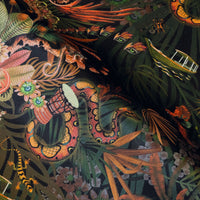 Close-up of snake, monkey and macaw among tropical flowers on Amazon Trip jungle print velvet fabric in black and gold