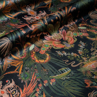 Rippled lengths of Amazon Trip black and gold jungle print velvet fabric for upholstery and cushions
