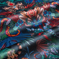 Rippled lengths of Amazon Trip midnight blue jungle print velvet fabric for upholstery and cushions