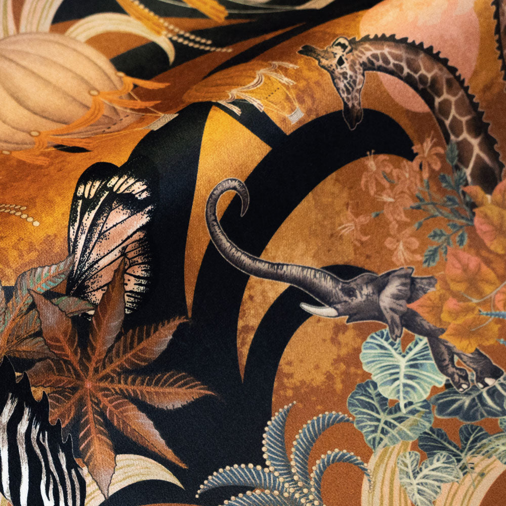 Detail of the elephants and giraffes on mustard yellow African animal print velvet furnishing fabric