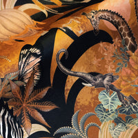 Detail of the elephants and giraffes on mustard yellow African animal print velvet furnishing fabric
