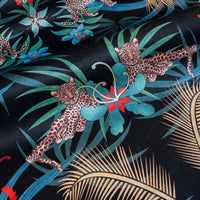 Detail of the leopards lazing among flowers on black and gold ornamental pattern velvet furnishing fabric