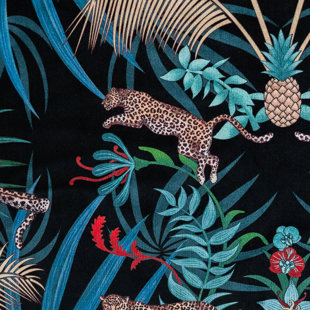 Close-up of the leaping leopard on black and gold patterned velvet upholstery fabric