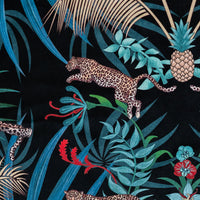 Close-up of the leaping leopard on black and gold patterned velvet upholstery fabric