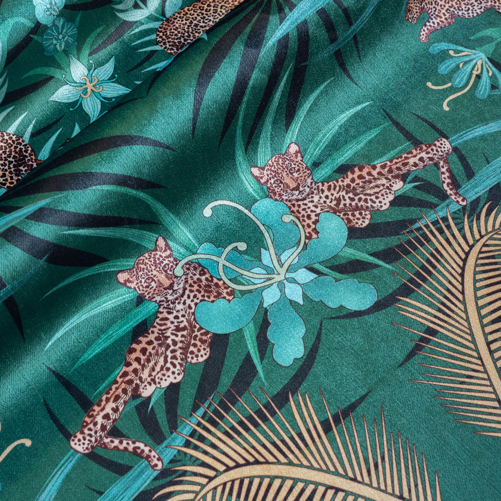 Detail of the leopards lazing among flowers on green and gold ornamental pattern velvet furnishing fabric