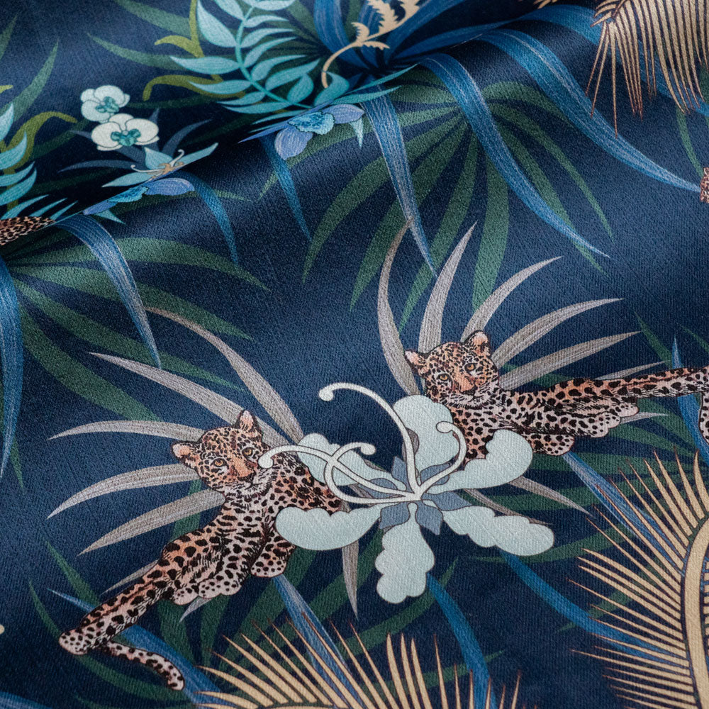 Detail of the leopards lazing among flowers on navy blue and gold ornamental pattern velvet furnishing fabric