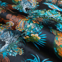 Rippled lengths of Magic Of India black Indian wildlife print velvet fabric for upholstery and cushions