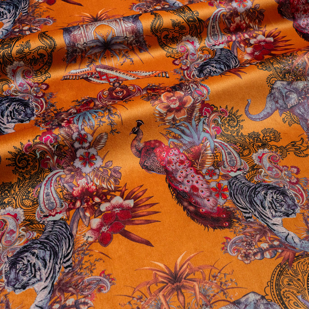 Rippled lengths of Magic Of India orange yellow Indian wildlife print velvet fabric for upholstery and cushions