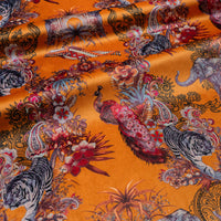 Rippled lengths of Magic Of India orange yellow Indian wildlife print velvet fabric for upholstery and cushions