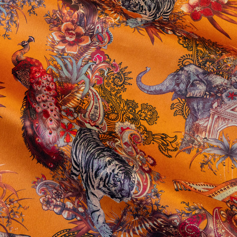 Macro of the soft velvet pile and fine print detail on orange yellow Indian wildlife print fabric