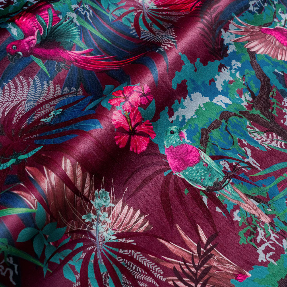 Rippled lengths of Rainforest Rush hot pink and claret tropical bird print velvet fabric for upholstery and cushions