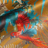 Detail of the orange Macaw bird on mustard yellow tropical bird print velvet furnishing fabric