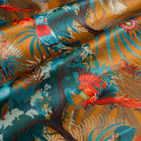 Rippled lengths of Rainforest Rush mustard yellow tropical bird print velvet fabric for upholstery and cushions