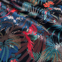 Detail of the birds and flowers on black red and gold tropical bird print velvet furnishing fabric