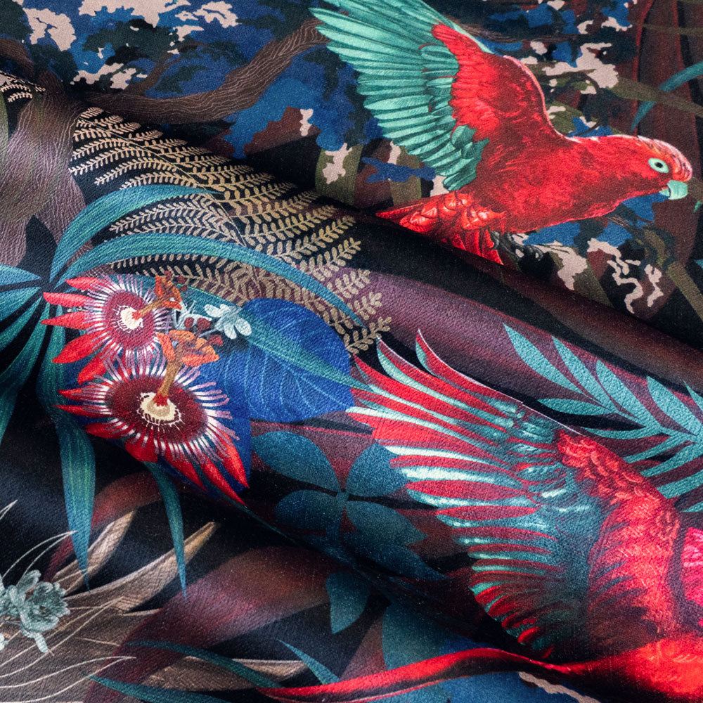 Detail of the wings and flowers on black red and gold tropical bird print velvet furnishing fabric