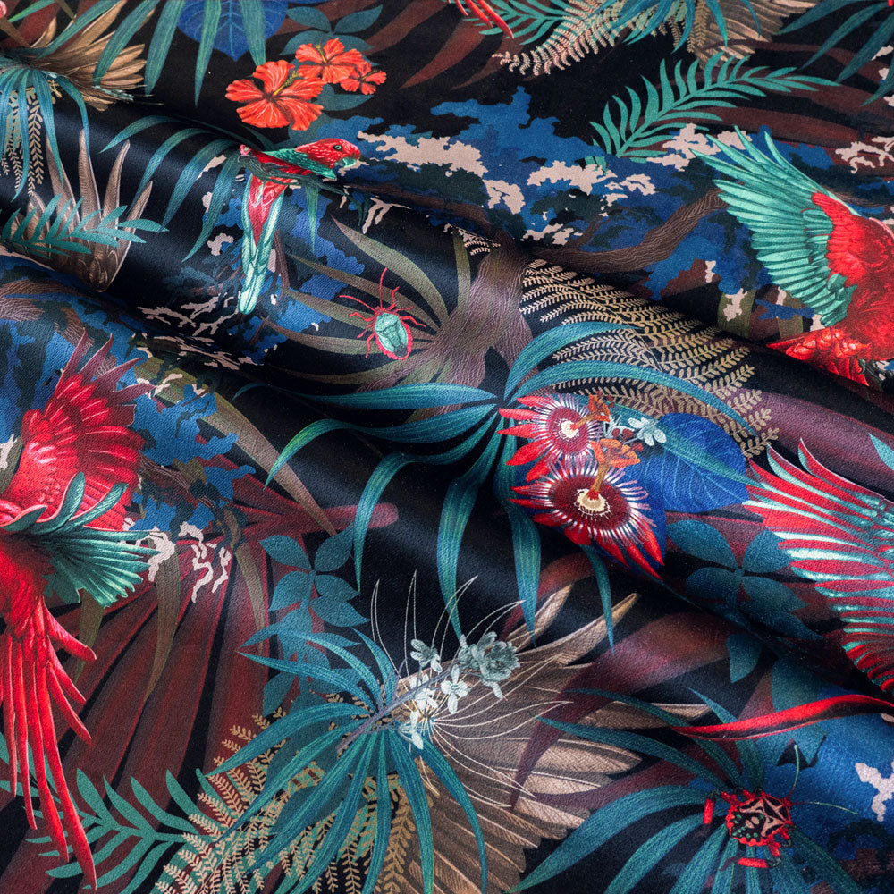 Rippled lengths of Rainforest Rush black red and gold tropical bird print velvet fabric for upholstery and cushions