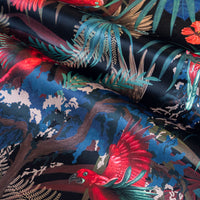 Rainforest Rush velvet fabric in black red and gold photographed at an angle to show the subtle sheen
