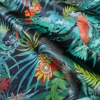 Rainforest Rush velvet fabric in colourful hues of green, blue and orange, photographed at an angle to show the subtle sheen