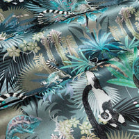 Rippled lengths of Treetop Tango dusky blue lemur print velvet fabric for upholstery and cushions