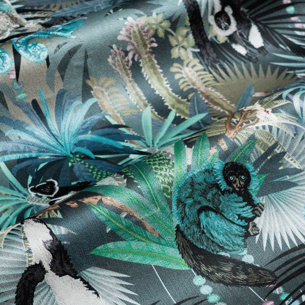 Treetop Tango velvet fabric in dusky blue photographed at an angle to show the subtle sheen and lemur