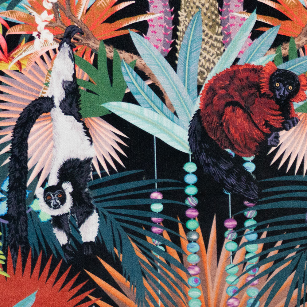 Close-up of lemurs and agate bead strands on Treetop Tango lemur print velvet fabric in dark colourful