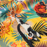 Close-up of swinging lemur on Treetop Tango lemur print velvet fabric in sunshine yellow
