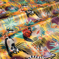 Rippled lengths of Treetop Tango sunshine yellow lemur print velvet fabric showing the sheen catching the light