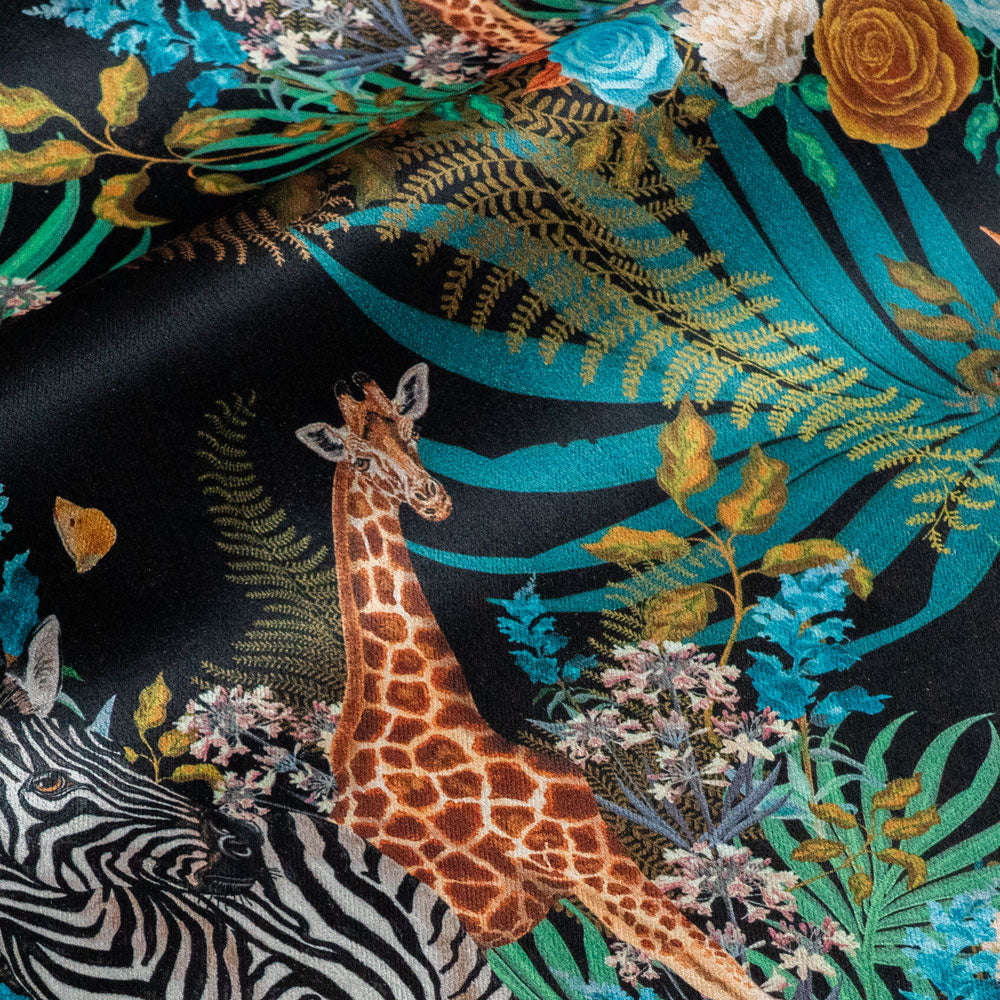 Detail of the giraffe on black African animal and floral print velvet furnishing fabric