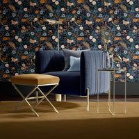 Interior scene with dark blue chair and Mustard Footstool in front of dark blue floral wallpaper by Becca Who