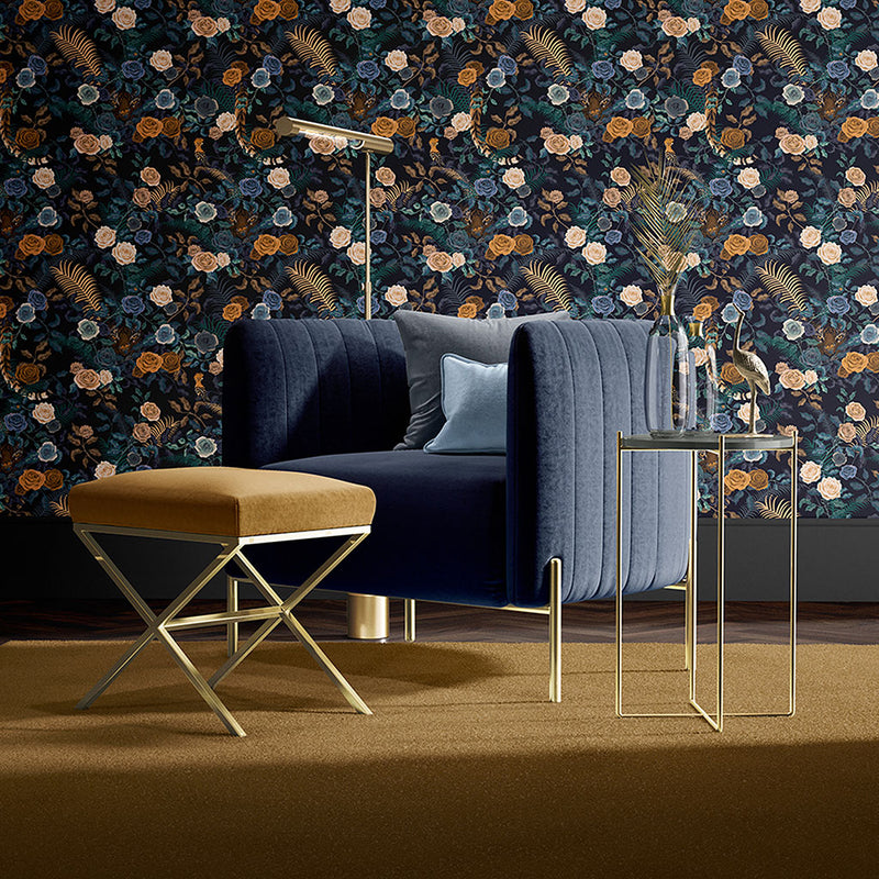 Interior scene with dark blue chair and Mustard Footstool in front of dark blue floral wallpaper by Becca Who
